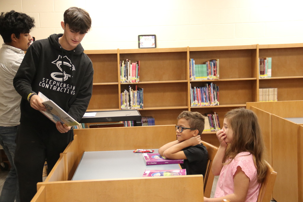 High schooler reads to students